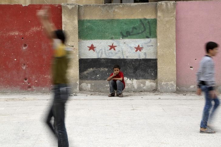 © Reuters. Meninos brincam num parquinho escolar na área de Seif al-Dawla, em Aleppo