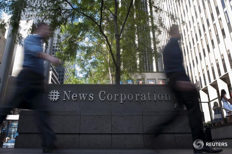 © Reuters. Passers-by walk near the News Corporation building in New York