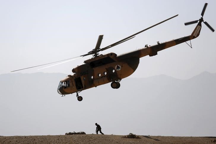 © Reuters. ANA helicopter flies over a soldier during a training exercise at the Kabul Military Training Centre in Afghanistan