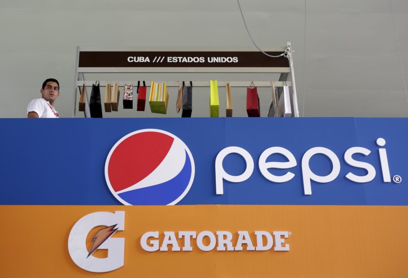 © Reuters. A man walks near logos of Pepsi and Gatorade at the U.S. pavilion during the Havana International Fair