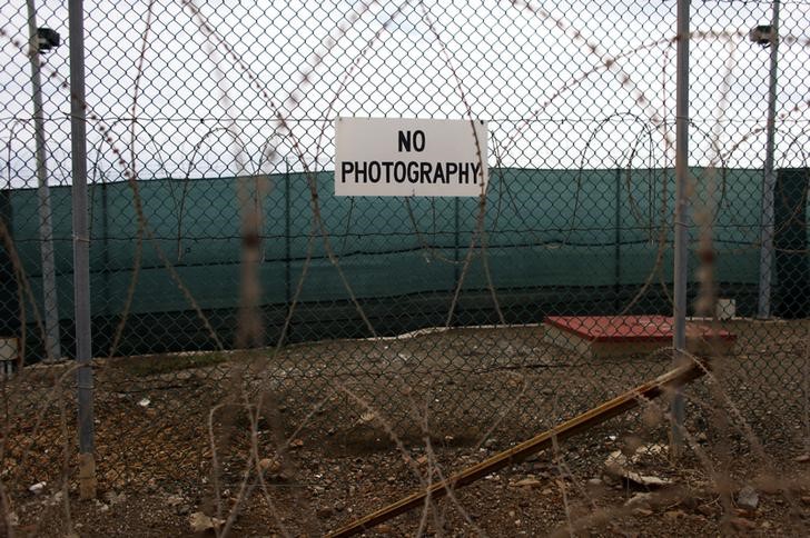 © Reuters. No photography signs are posted on the fence surrounding Camp Delta at the U.S. Naval Base at Guantanamo Bay