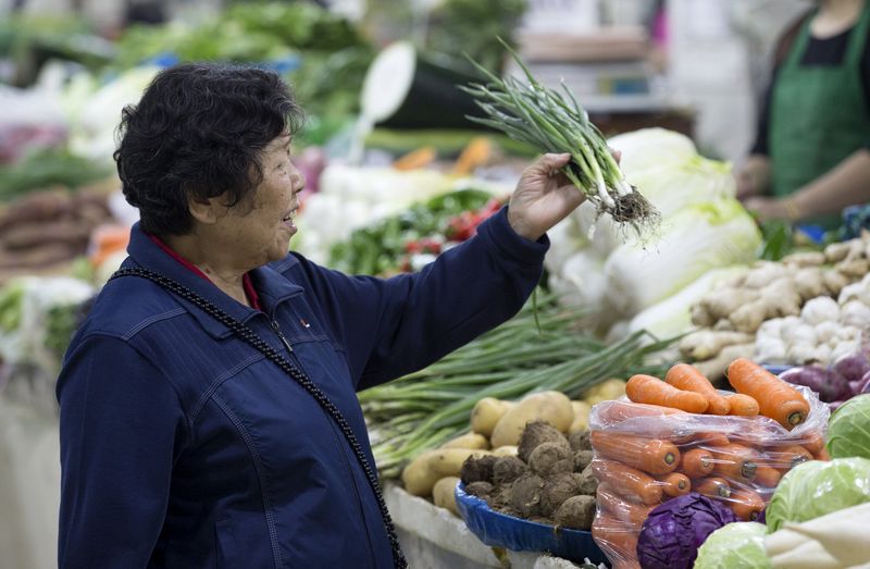 © Reuters. A customer selects vegetables at a market in Nanjing