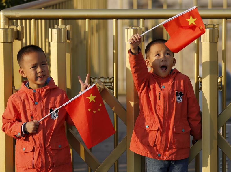 © Reuters. Gêmeos segurando bandeiras da China em Pequim