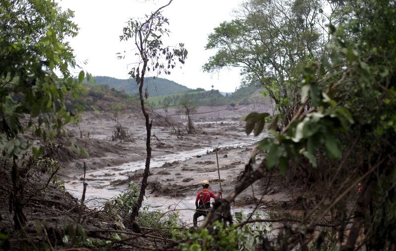 © Reuters. Equipe de resgate em área tomada pela lama de barragens da Samarco que romperam