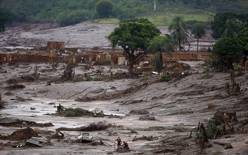 © Reuters. Equipe de resgate em área tomada pela lama de barragens da Samarco que romperam