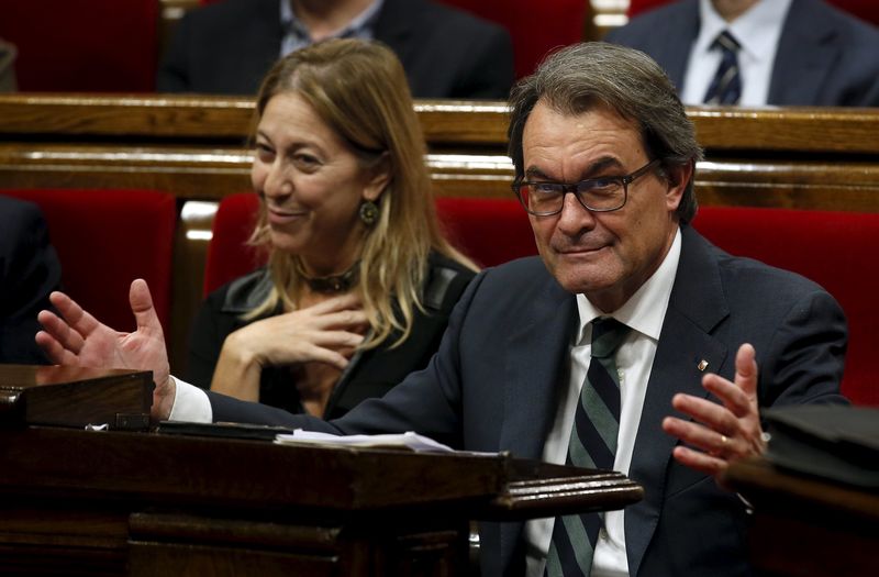 © Reuters. Catalan acting President Artur Mas gestures, next to Neus Munte, during the election session for the new President at Catalunya's Parliament in Barcelona