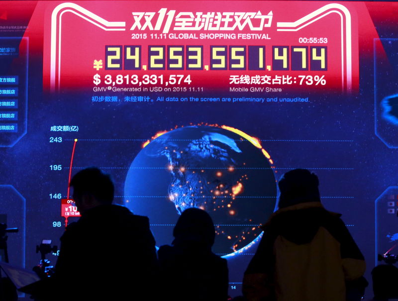 © Reuters. Journalists look at a screen showing real-time data of transactions at Alibaba Group's 11.11 Global shopping festival in Beijing