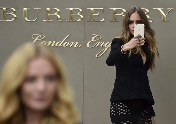 © Reuters. Британская модель Кара Делевинь делает селфи во время показа коллекции Burberry Spring/Summer 2016 на Неделе моды в Лондоне