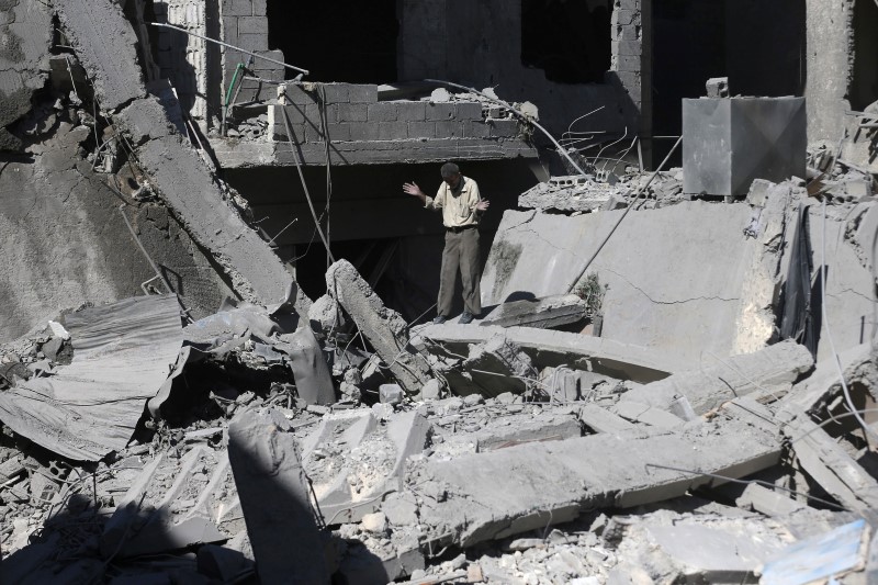 © Reuters. A man reacts amid rubble from what activists said was barrel bombs dropped by forces loyal to Syria's President Bashar Al-Assad in Douma, eastern Ghouta, near Damascus