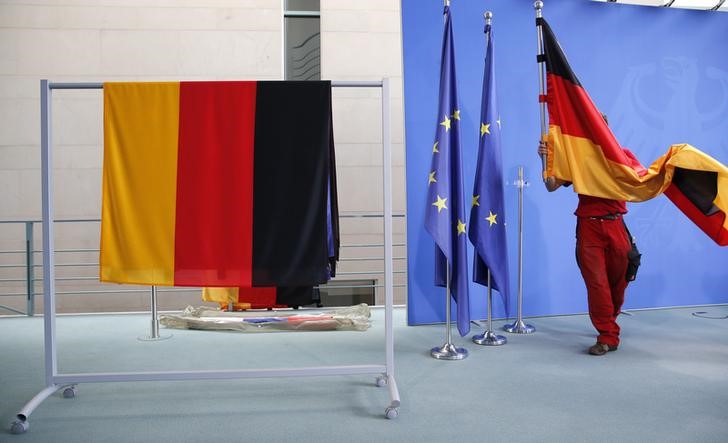 © Reuters. Funcionária colocando bandeira nacional da Alemanha antes de evento em Berlim