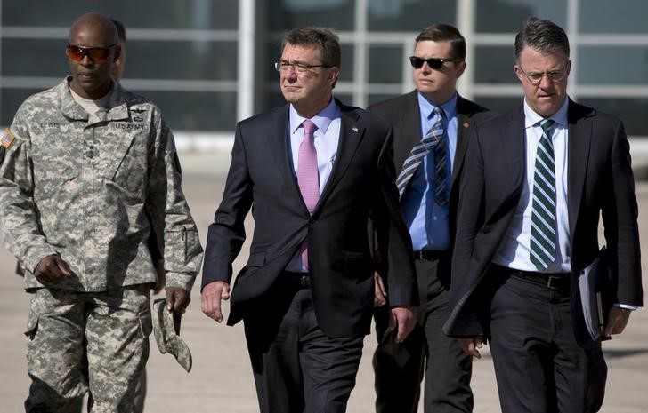 © Reuters. U.S. Defense Secretary Carter, accompanied by his Chief of Staff Rosenbach and U.S. Army Lt. Gen. Lewis, walks on the tarmac before boarding his plane at Queen Alia Airport in Amman