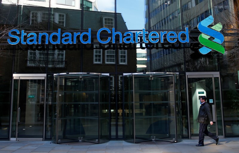 © Reuters. A man walks past the head office of Standard Chartered bank in the City of London