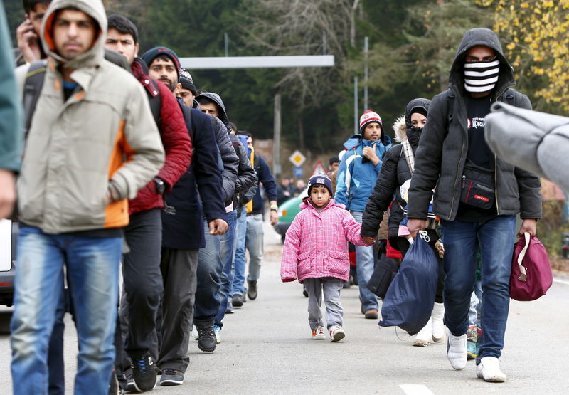 © Reuters. Migrants walk along street after passing Austrian-German border near Wegscheid