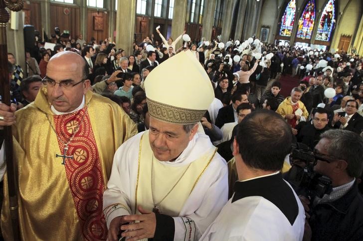 © Reuters. Bishop Barros attends his first religious service as citizens protest against him at the Osorno cathedral