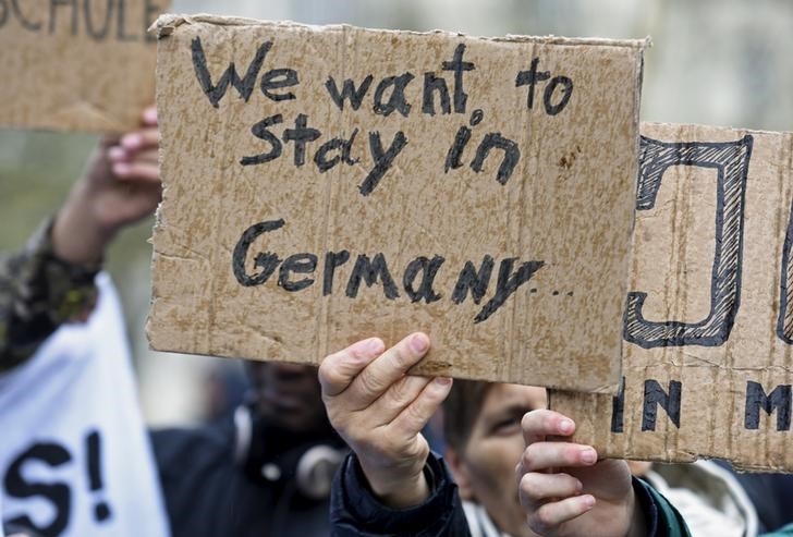 © Reuters. Un grupo de personas sostienen carteles durante una manifestación a favor de los refugiados en Hamburgo, Alemania