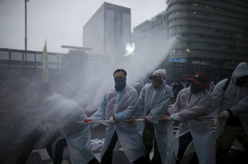 © Reuters. Water mixed with tear gas liquid is sprayed by police water canon to disperse protesters during an anti-government rally in central Seoul