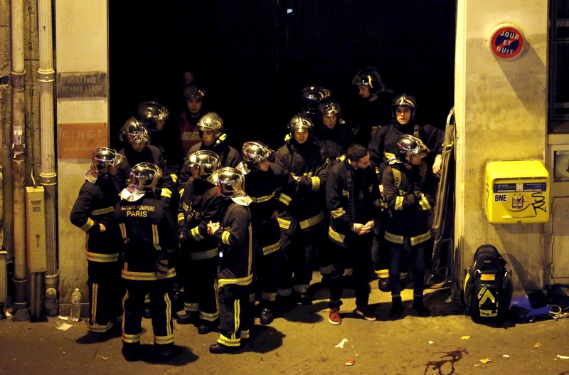 © Reuters. French fire brigade members gather near the Bataclan concert hall following fatal shootings in Paris