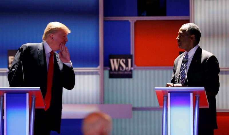 © Reuters. Republican U.S. presidential candidate Trump whispers across to Carson during the debate held by Fox Business Network for the top 2016 U.S. Republican presidential candidates in Milwaukee