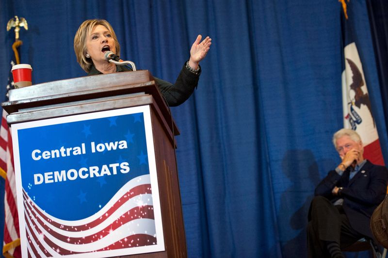 © Reuters. Democratic U.S. presidential candidate Clinton speaks as Former president Clinton listens at the Central Iowa Democrats Fall Barbecue in Ames, Iowa