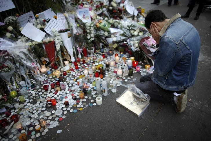 © Reuters. Homem prestando homenagem às vítimas de ataques em Paris