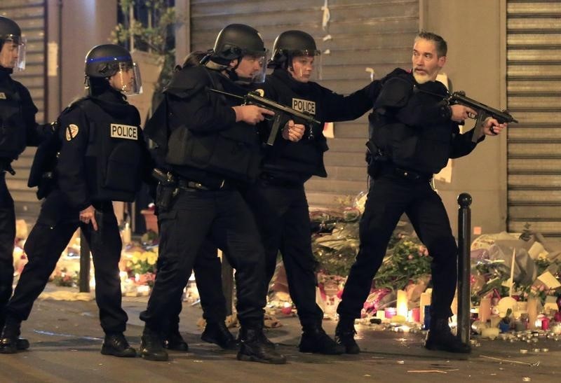 © Reuters. Policiais vasculhando veículo suspeito próximo ao restaurante La Carillon, após ataques em Paris