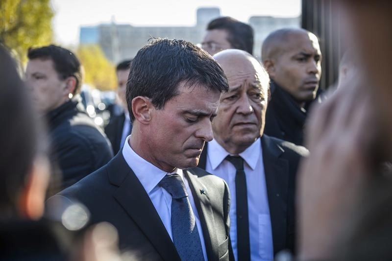 © Reuters.  French Prime Minister Manuel Valls and French Defense Minister Jean-Yves Le Drian react as they speak to journalists after they visited the psychological help center at the Ecole Militaire in Paris