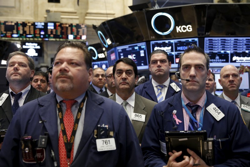 © Reuters. Traders on hold a moment of silence in response to the Paris attacks on the floor of the New York Stock Exchange 