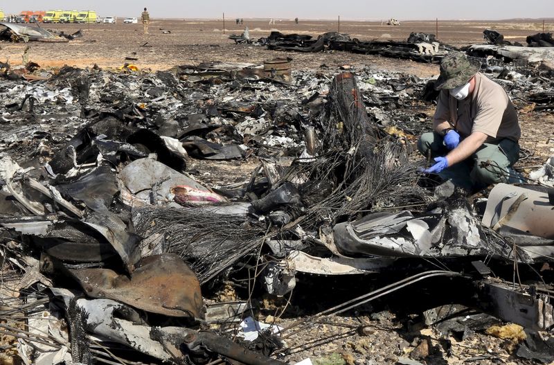 © Reuters. Investigador analisando destroços de um avião de passageiros russo que caiu no Egito