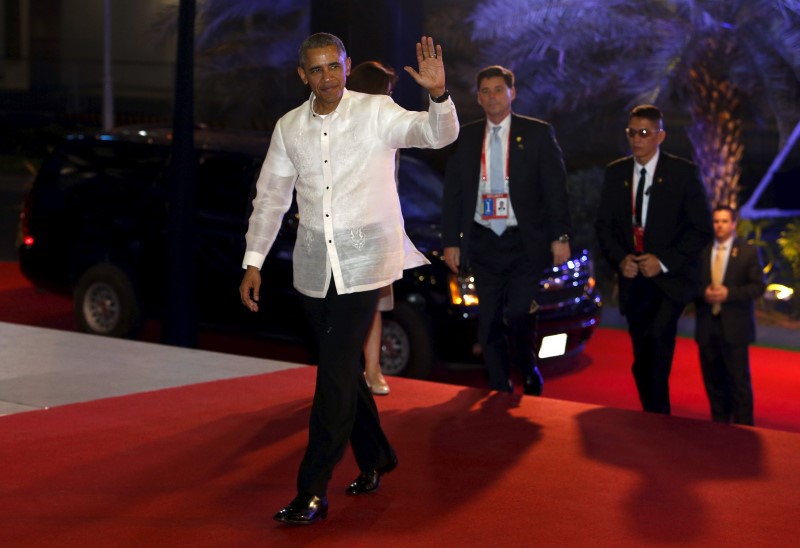 © Reuters. U.S. President Barack Obama, wearing the traditional Philippine "barong", waves as he arrives for a welcome dinner during the Asia-Pacific Economic Cooperation (APEC) summit in Manila