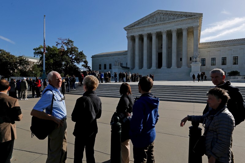 © Reuters. Visitors wait in line at the U.S. Supreme Court building to watch arguments on the first day of the court's new term in Washington