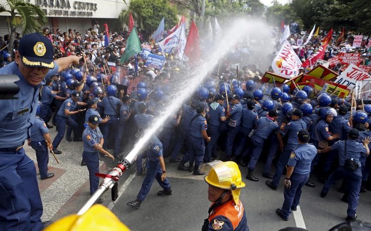 © Reuters. الشرطة تستخدم مدافع المياه لتفريق محتجين اثناء قمة ابيك