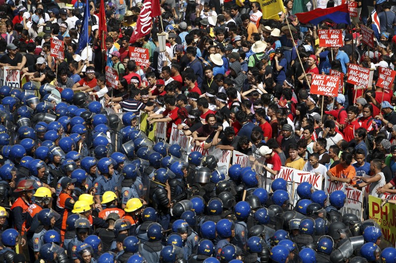 © Reuters. Protesters face riot police near the venues of the Asia-Pacific Economic Cooperation (APEC) summit in Manila