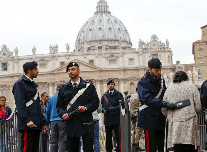 © Reuters. Policiais italianos inspecionam os participantes da audiência geral do papa Francisco