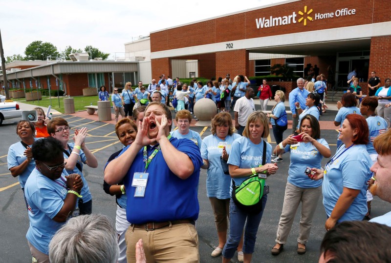 © Reuters. Jared Lawrence leads employees of Wal-Mart Stores, Inc. in a company chant before a tour in Bentonville, Arkansas