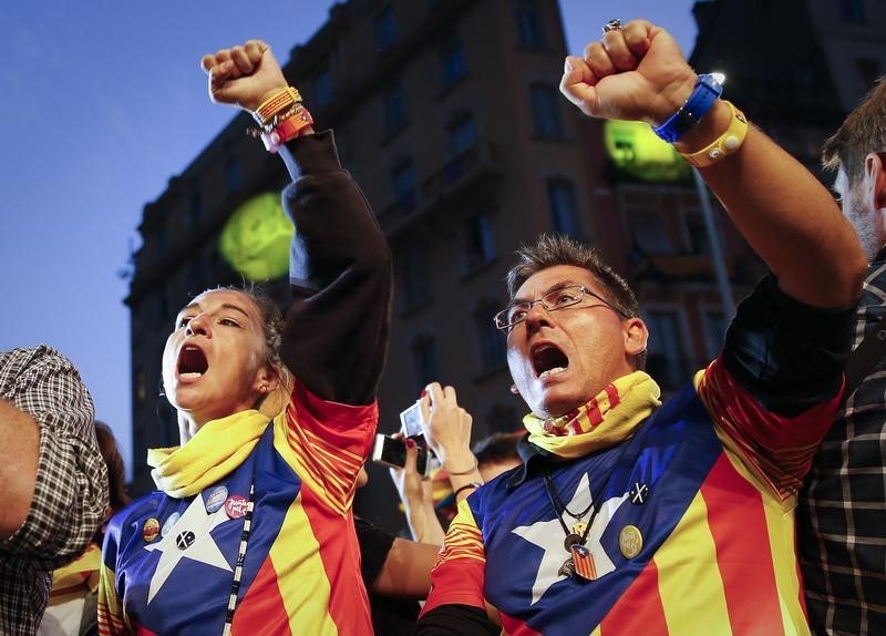 © Reuters. Junts Pel Si (Together For Yes) supporters wear a pro-independence "Estelada" shirts after a regional parliamentary election in Barcelona