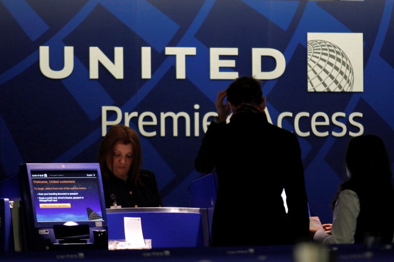 © Reuters. A worker from United attends to some customers during their check in process at Newark International airport in New Jersey