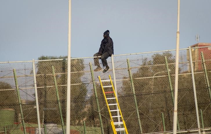 © Reuters. Casi 100 personas intentan saltar la valla de Melilla, dos llegaron a suelo español