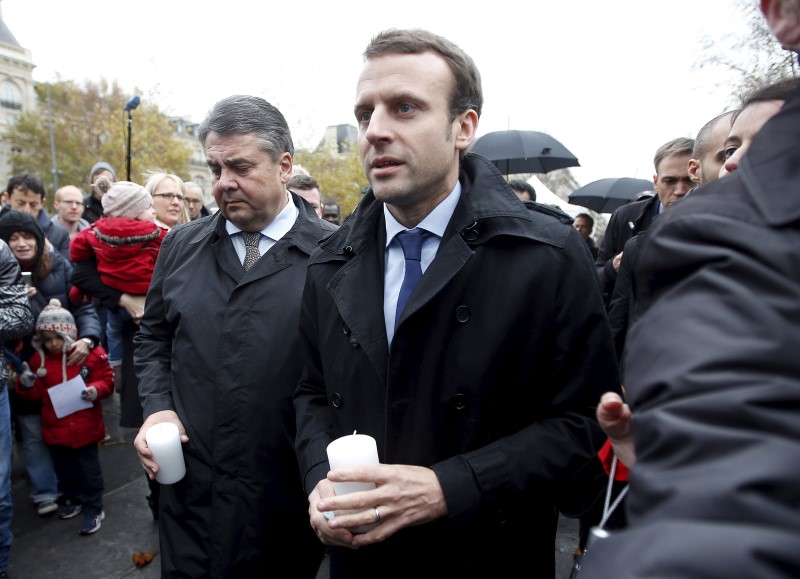 © Reuters. Ministro de Economía de Francia, Emmanuel Macron, y su contraparte de Alemania, Sigmar Gabriel, llevan velas en la Plaza de la República una semana después de los mortales ataques en París