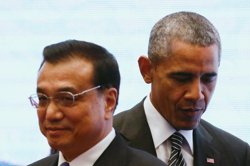 © Reuters. U.S. President Obama walks behind China's Premier Li as they attend a family photo at the 27th ASEAN Summit in Kuala Lumpur