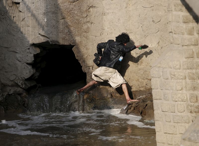 © Reuters. A man runs away during a police round up of suspected drug addicts in Kabul, Afghanistan