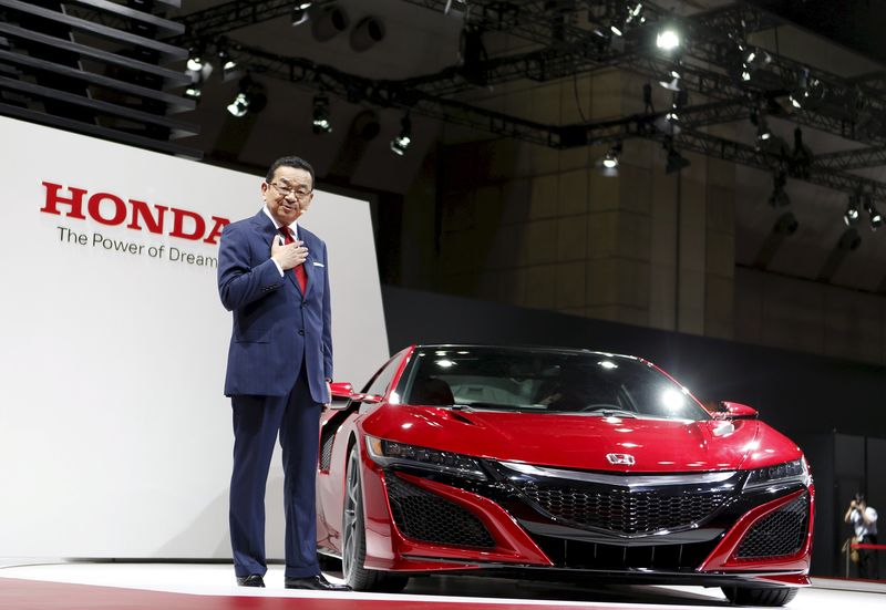 © Reuters. Honda Motor Co President and Chief Executive Takahiro Hachigo speaks next to NSX during a presentation at the 44th Tokyo Motor Show in Tokyo, Japan