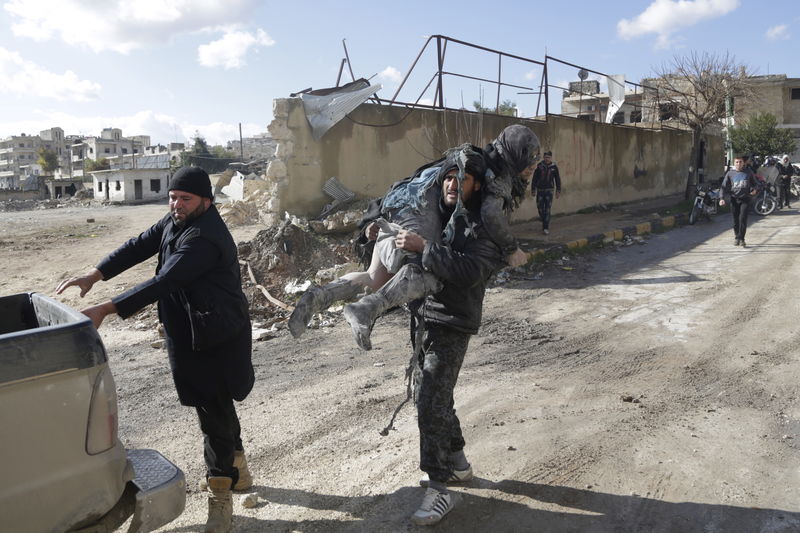 © Reuters. A man carries an injured woman in a site hit by what activists said were airstrikes carried out by the Russian air force in the rebel-controlled area of Maaret al-Numan town in Idlib province, Syria 