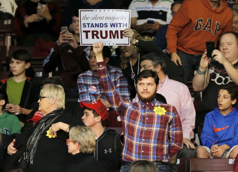 © Reuters. A protester stands as republican presidential candidate Donald Trump speaks during a campaign event in Rock Hill