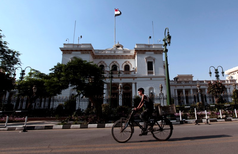 © Reuters. A boy rides a bike in front of the parliament building in Cairo