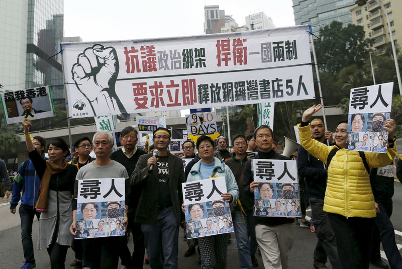 © Reuters. Manifestantes sostienen retratos de cinco trabajadores de una editorial y de una librería desaparecidos en Hong Kong