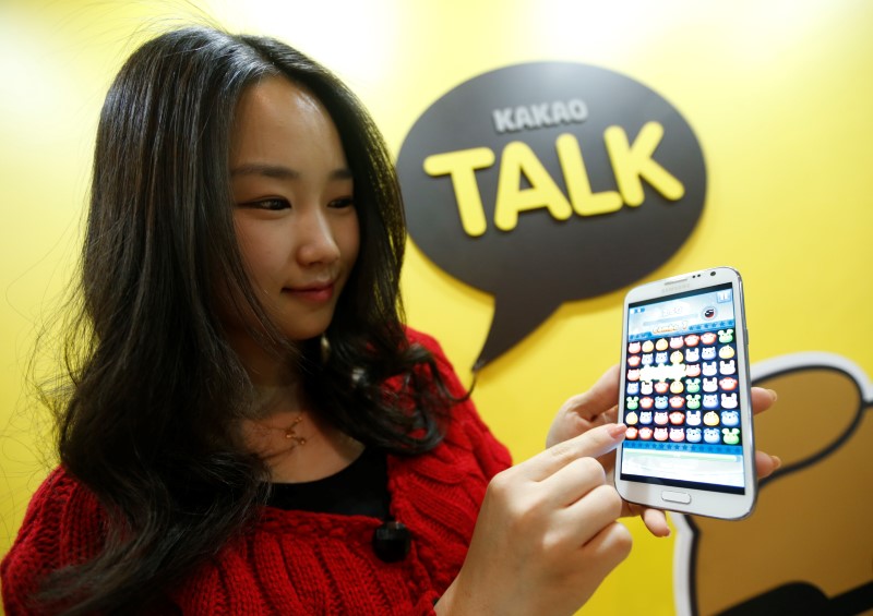 © Reuters. An employee of mobile messager Kakao Talk displays the mobile game "Anipang" on a smartphone at the company in Seongnam