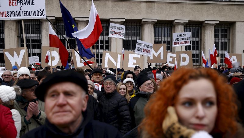 © Reuters. People hold placards with letters as they gather during an anti-government demonstration for free media in front of the Television headquarter in Warsaw