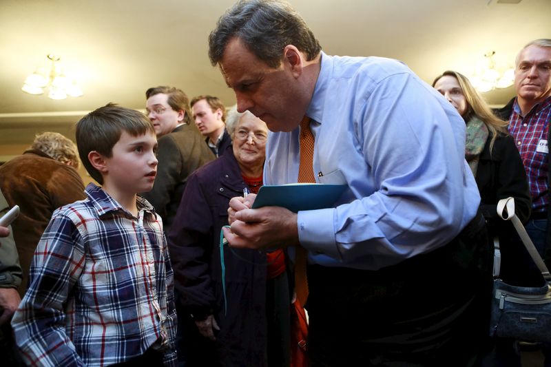 © Reuters. U.S. Republican presidential candidate and New Jersey Governor Chris Christie signs a notebook for Ethan Long at a campaign town hall meeting in Merrimack