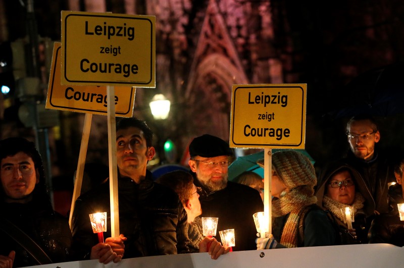 © Reuters. Participants hold candles and posters reading "Lepizig shows courage" during a protest against LEGIDA, the Leipzig arm of the anti-Islam movement PEGIDA, in front of St. Nicholas Church in Leipzig