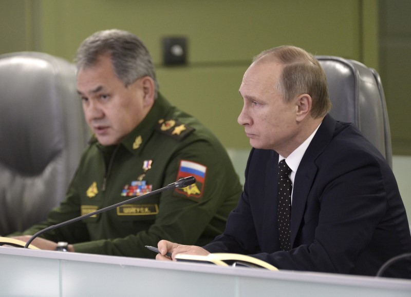 © Reuters. Russian President Putin with Defence Minister Shoigu attend meeting on Russian air force's activity in Syria at national defence control centre in Moscow